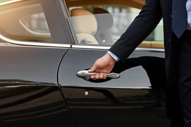 Chauffeur opening door of limousine