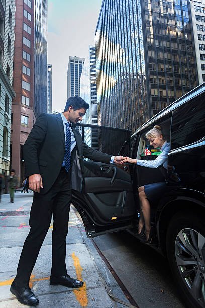 Chauffeur opening door of limousine